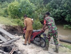 Wujud Kepedulian, Babinsa Koramil 08/Alafan Bantu Warga Lewati Jembatan Rusak