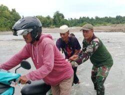 Babinsa membantu & mengarahkan masyarakat menyebrangi sungai yg banjir pasca hujan